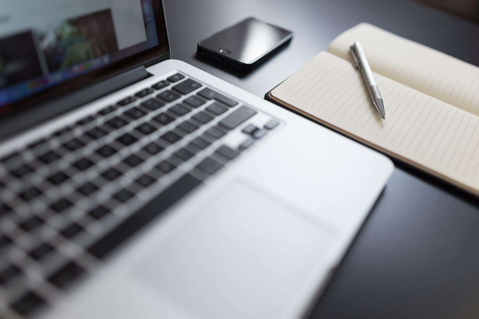 Laptop, notebook and smartphone arranged on a desk